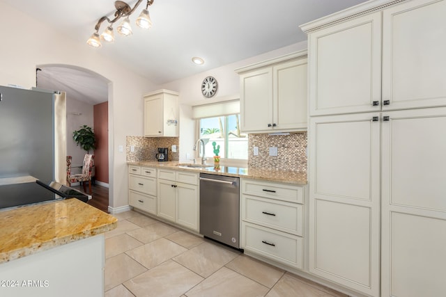 kitchen featuring light stone countertops, sink, dishwasher, and decorative backsplash