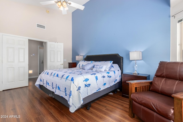 bedroom featuring ceiling fan, a towering ceiling, and dark hardwood / wood-style floors