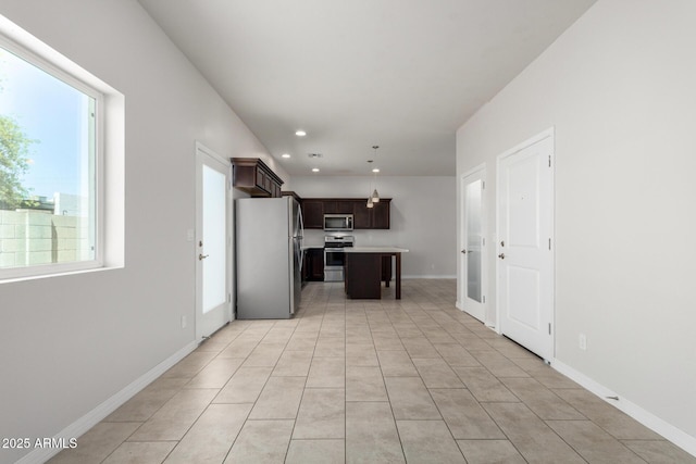 2000 N 36th St Unit 8, Phoenix, AZ 85008 - kitchen with stainless steel appliances, light countertops, dark brown cabinetry, a kitchen island, and light tile patterned floors