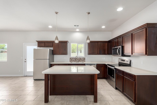 2000 N 36th St Unit 8, Phoenix, AZ 85008 - kitchen with stainless steel appliances, light countertops, a kitchen island, light tile patterned floors, and hanging light fixtures