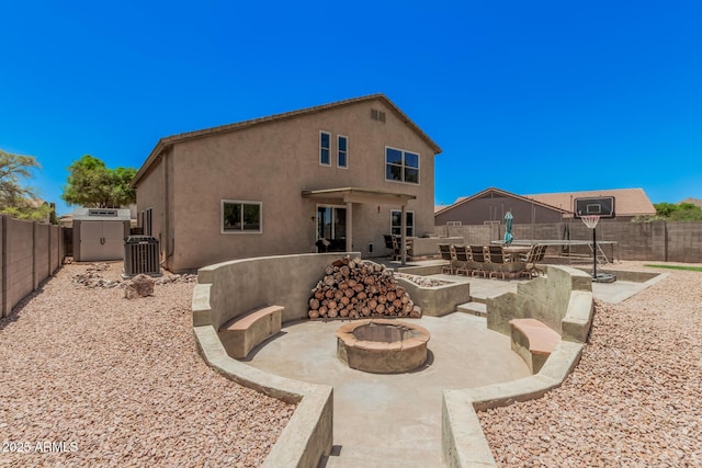 3016 W White Canyon Rd, San Tan Valley, AZ 85144 - back of house with an outdoor fire pit, a patio area, a storage shed, a fenced backyard, and stucco siding