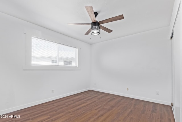 spare room with ceiling fan and dark wood-type flooring