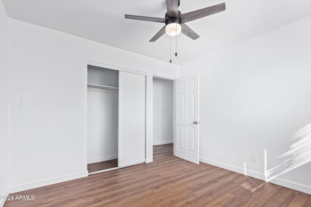 unfurnished bedroom featuring hardwood / wood-style flooring, ceiling fan, and a closet