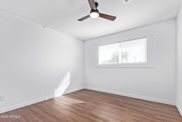 spare room featuring ceiling fan and dark wood-type flooring