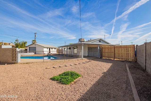 rear view of property with a fenced in pool