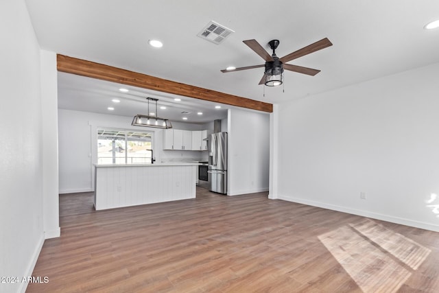 unfurnished living room with ceiling fan and light wood-type flooring