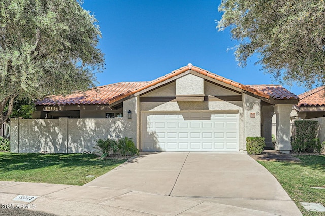 10023 E Sunnyslope Ln, Scottsdale, AZ 85258 - view of front of house featuring a tiled roof, a garage, concrete driveway, and stucco siding
