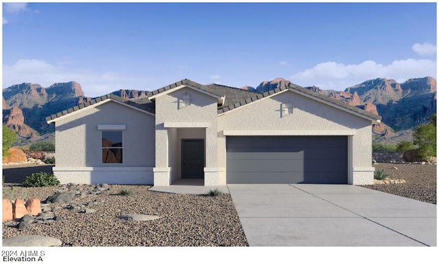 view of front of house with stucco siding, a mountain view, concrete driveway, and a garage