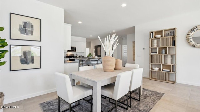 dining space featuring light tile patterned flooring, recessed lighting, and baseboards