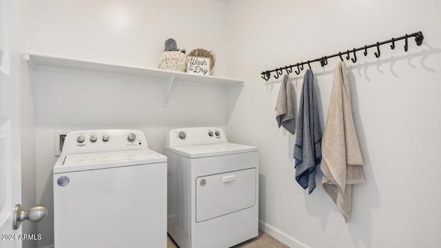 clothes washing area featuring washer and clothes dryer, laundry area, and baseboards