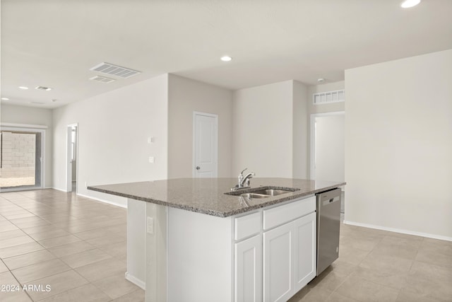 kitchen with stainless steel dishwasher, dark stone counters, visible vents, and a sink