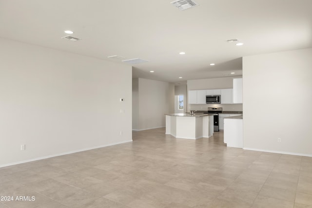 unfurnished living room featuring visible vents, recessed lighting, and baseboards