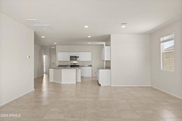 unfurnished living room with visible vents, recessed lighting, and baseboards