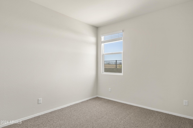 spare room with baseboards and carpet