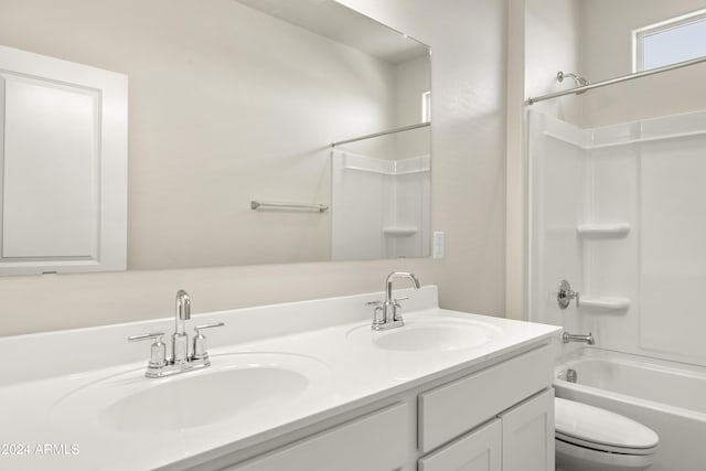 bathroom with double vanity, toilet, washtub / shower combination, and a sink