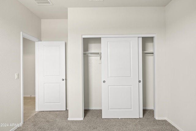 unfurnished bedroom featuring a closet, visible vents, baseboards, and carpet floors