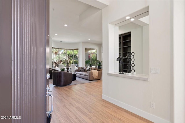 hall with baseboards, wood finished floors, and recessed lighting