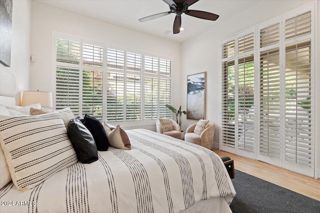 bedroom featuring multiple windows, a ceiling fan, and wood finished floors