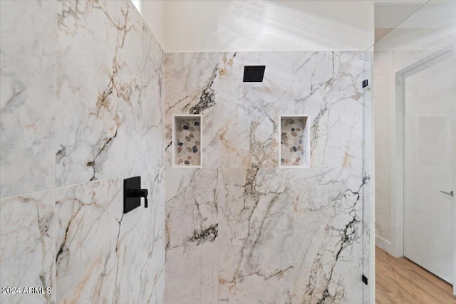 bathroom featuring tiled shower, tile walls, and hardwood / wood-style flooring