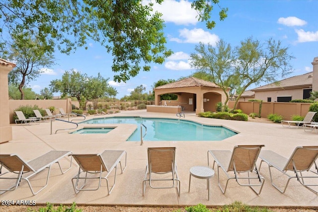 pool featuring a community hot tub, a patio, a gazebo, and a fenced backyard