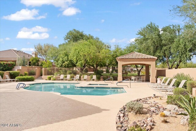 view of swimming pool featuring a community hot tub, a gazebo, and a patio