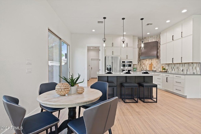 dining room featuring light wood-type flooring, visible vents, and recessed lighting