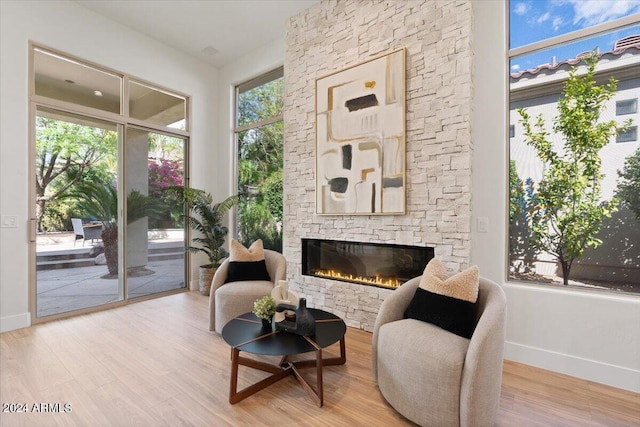 living area with light wood-style floors, a fireplace, and baseboards