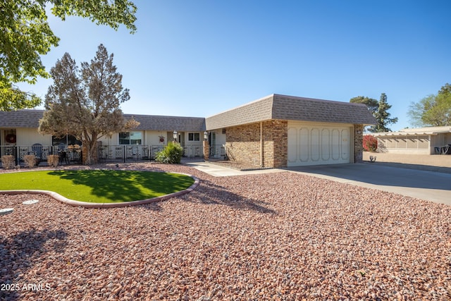 single story home featuring driveway, a garage, a shingled roof, mansard roof, and fence