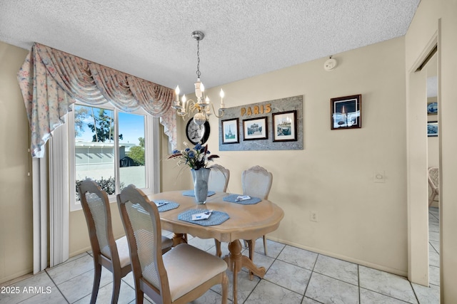 dining area featuring a chandelier, a textured ceiling, and tile patterned floors