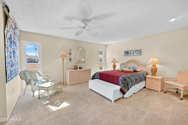 carpeted bedroom featuring ceiling fan, baseboards, and a textured ceiling