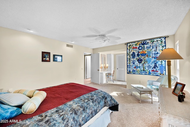 bedroom featuring a textured ceiling, carpet floors, visible vents, and a ceiling fan