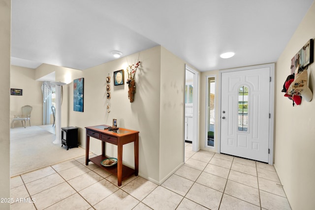 foyer featuring light colored carpet and light tile patterned floors