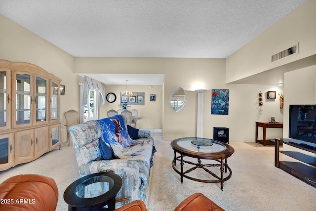 living area featuring light carpet, an inviting chandelier, visible vents, and a textured ceiling