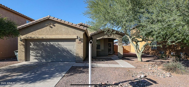 view of front of house featuring concrete driveway, an attached garage, a tile roof, and stucco siding