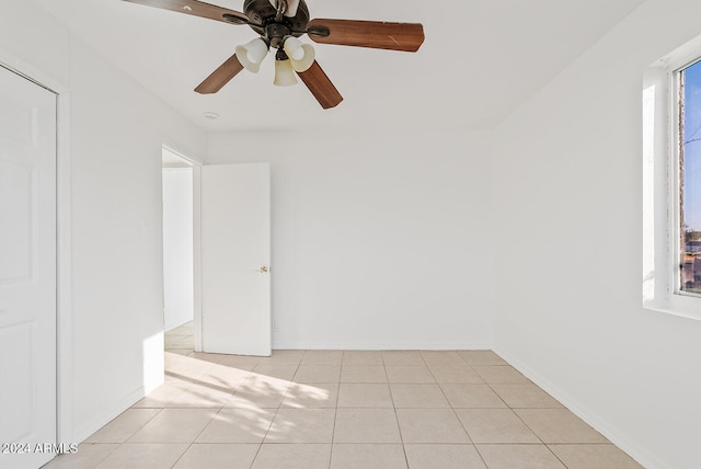 tiled empty room featuring ceiling fan