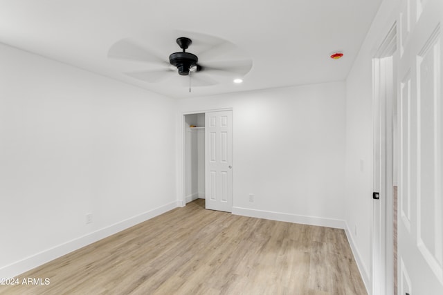 unfurnished bedroom with ceiling fan, a closet, and light hardwood / wood-style flooring