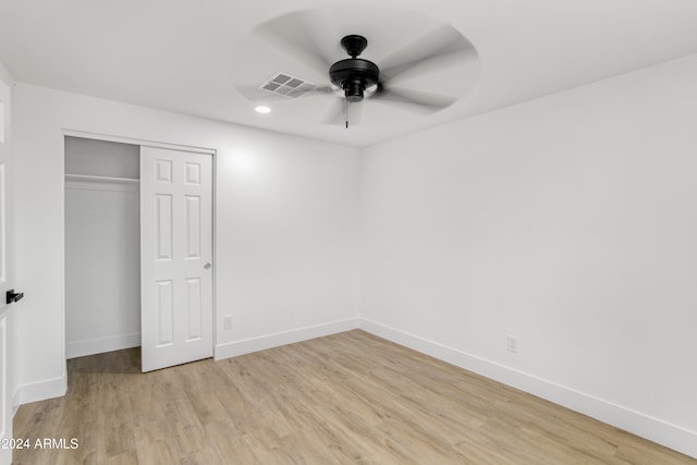 unfurnished bedroom featuring ceiling fan, a closet, and light wood-type flooring