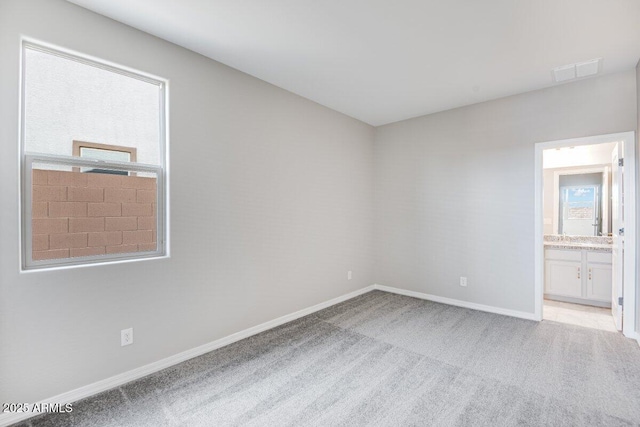 carpeted empty room featuring visible vents and baseboards