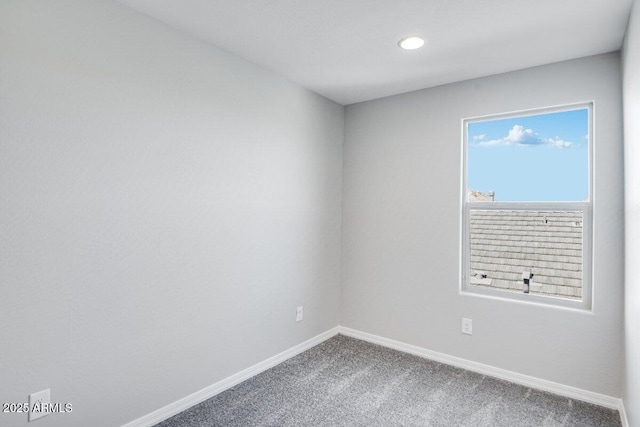 carpeted empty room featuring baseboards