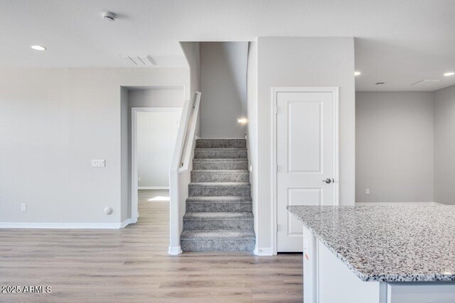 staircase featuring recessed lighting, wood finished floors, visible vents, and baseboards