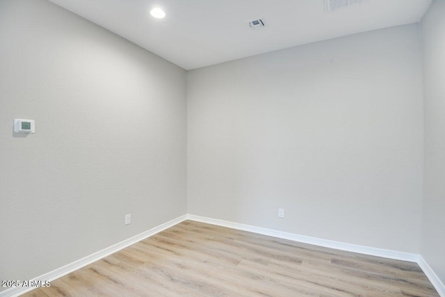 empty room with recessed lighting, visible vents, light wood-style flooring, and baseboards