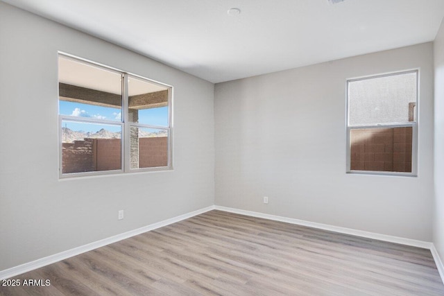 unfurnished room with baseboards and wood finished floors