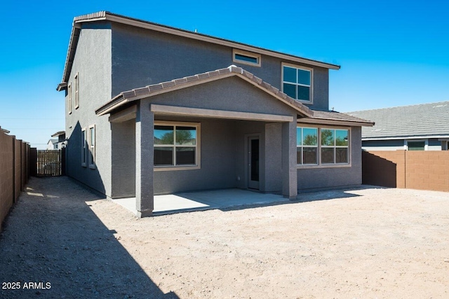 back of house with a patio area, a fenced backyard, and stucco siding