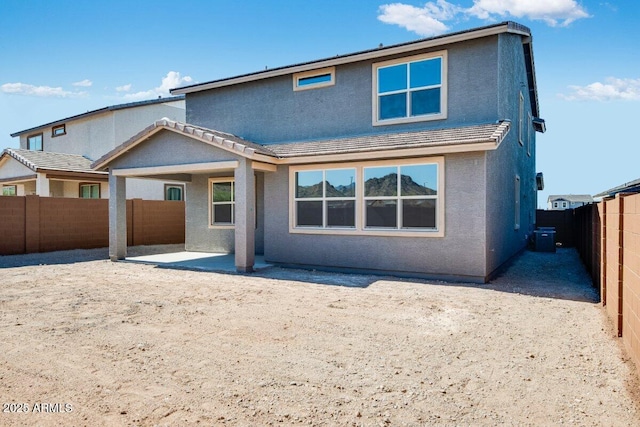 back of house with central air condition unit, a fenced backyard, a patio, and stucco siding