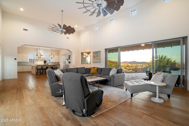 6535 W Gold Mountain Pass, Phoenix, AZ 85083 - living area featuring ceiling fan, light wood-style floors, arched walkways, recessed lighting, and a towering ceiling