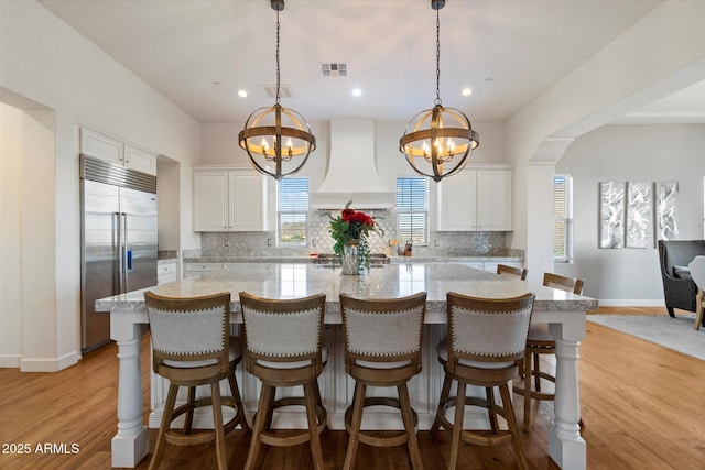 6535 W Gold Mountain Pass, Phoenix, AZ 85083 - kitchen with backsplash, a notable chandelier, stainless steel built in fridge, and premium range hood