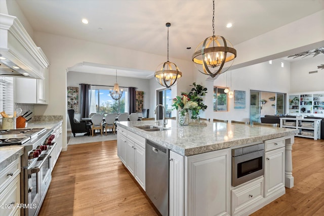 6535 W Gold Mountain Pass, Phoenix, AZ 85083 - kitchen with appliances with stainless steel finishes, a sink, premium range hood, an inviting chandelier, and white cabinetry