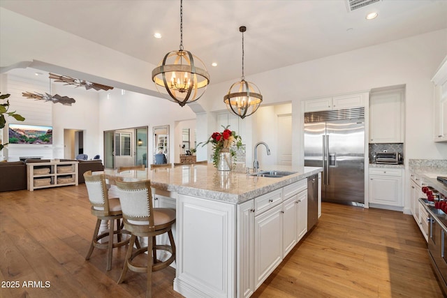 6535 W Gold Mountain Pass, Phoenix, AZ 85083 - kitchen featuring white cabinets, a notable chandelier, a sink, open floor plan, and high end appliances