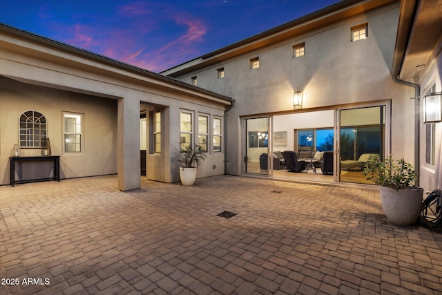6535 W Gold Mountain Pass, Phoenix, AZ 85083 - back of house at dusk with a patio and stucco siding