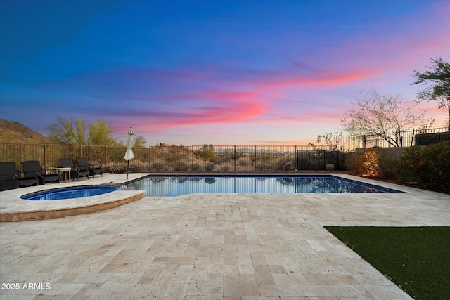 6535 W Gold Mountain Pass, Phoenix, AZ 85083 - pool at dusk featuring a patio, a pool with connected hot tub, and a fenced backyard